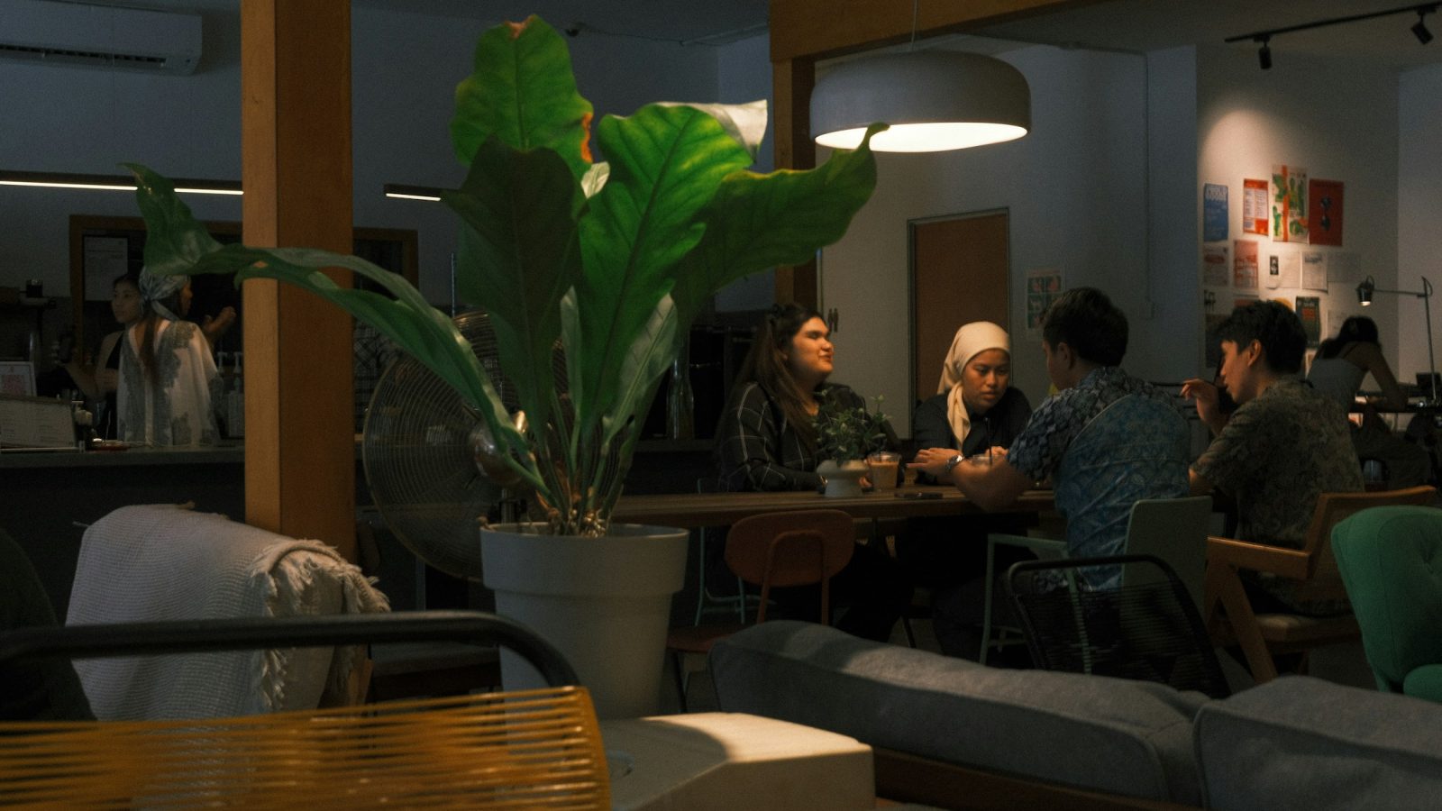 Mehrere Menschen sitzen bei Kaffee an einem Tisch und unterhalten sich