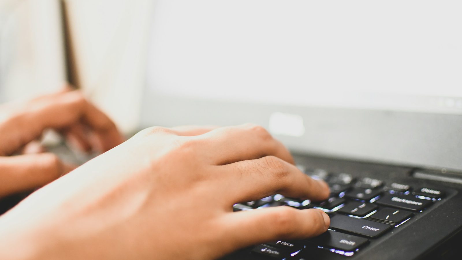 Nahaufnahme tippender Hände auf einer Laptop-Tastatur als Symbolbild für den Online-Wohngeldantrag