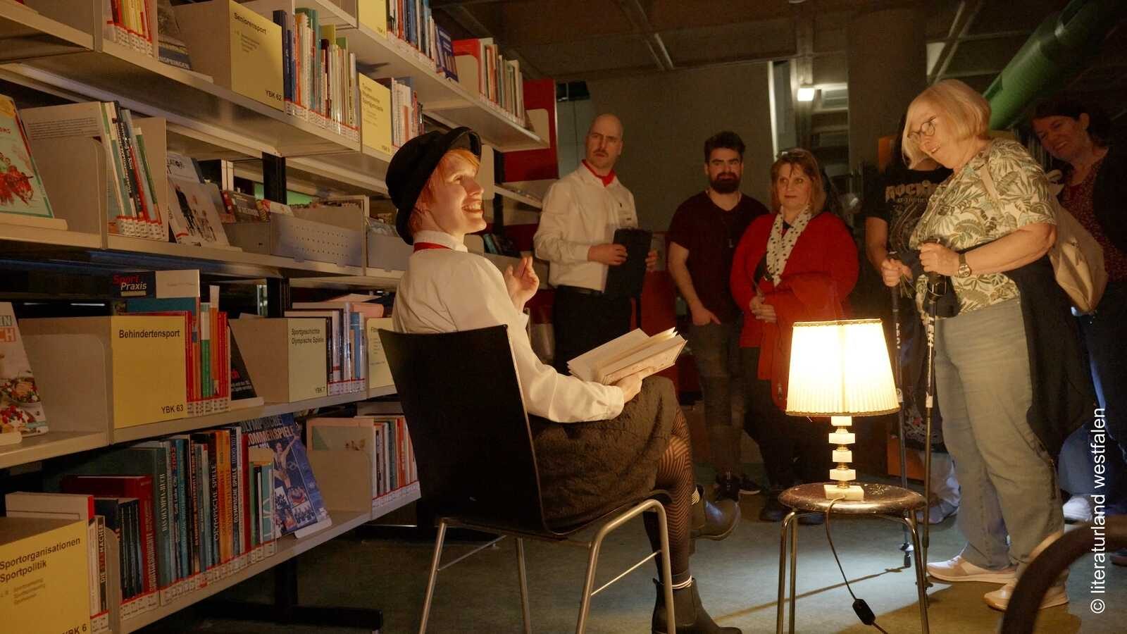 Szenenfoto aus dem interaktiven Theaterstück Fantastische Zeiten zwischen Seiten mit der Figur Miss Marple in einer Bücherei