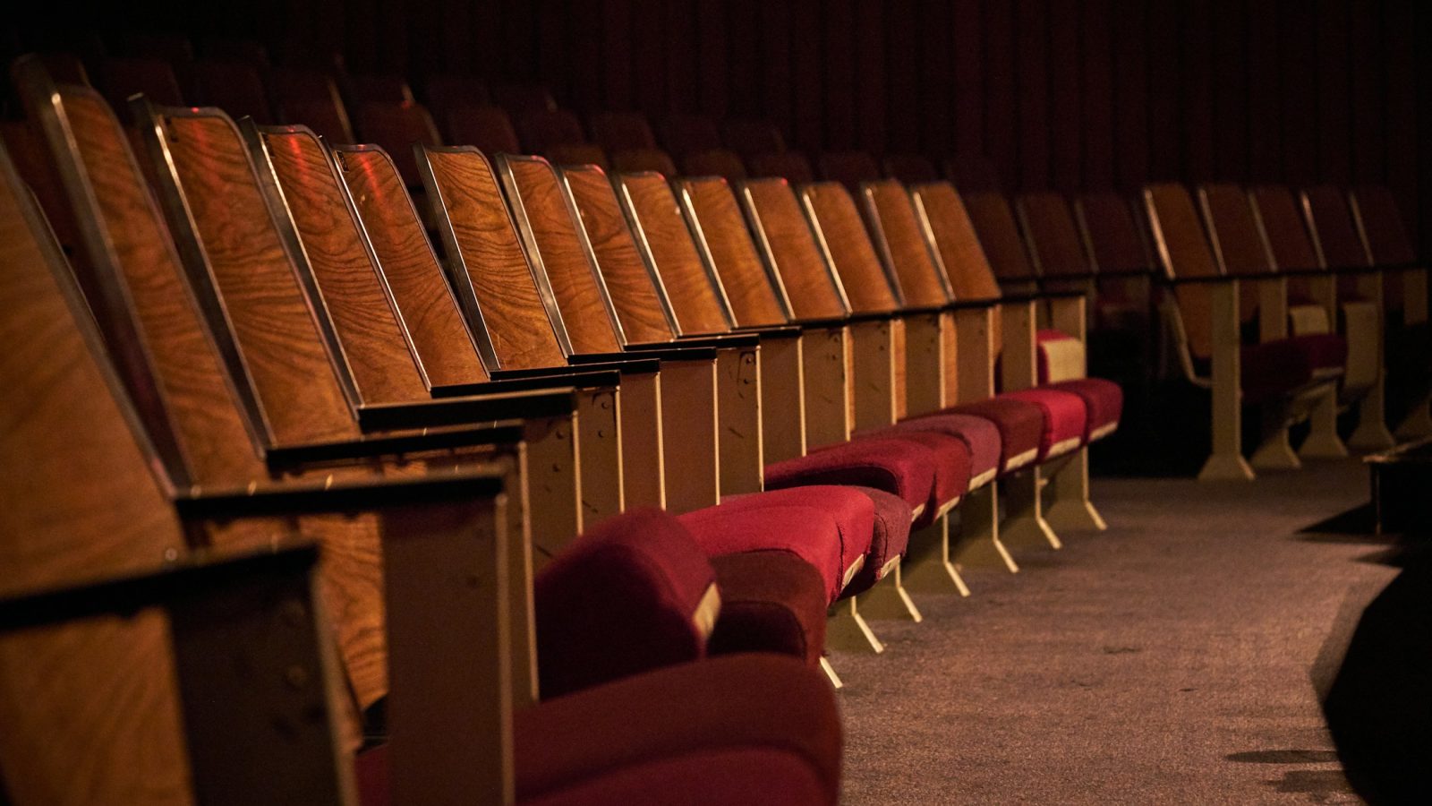 Rote Sitzreihen in einem leeren Theatersaal