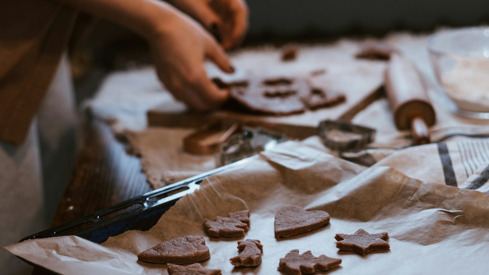 Hände stechen Weihnachtsplätzchen aus ausgerolltem Teig aus