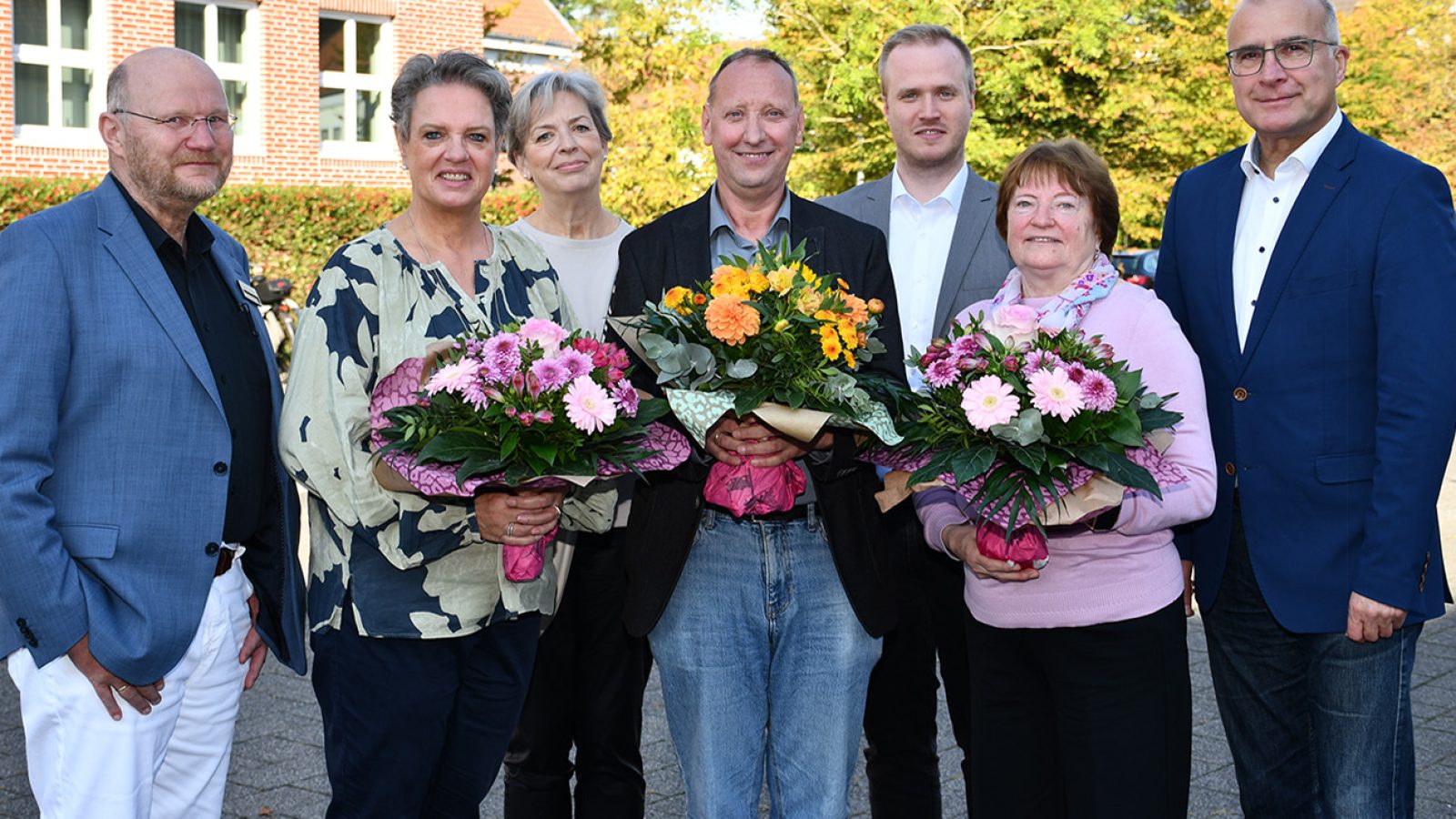 Erster Stadtrat Wigbert Grotjan mit den Dienstjubilaren Christine Bruns, Heinz-Georg Thoben und Ludmilla Repp, die Blumen halten, sowie Fachbereichsleitern und Personalrat im Ratssaal Cloppenburg