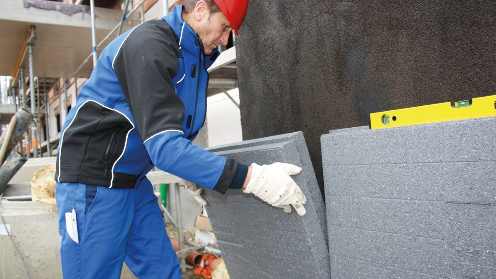 Ein Bauarbeiter verlegt Dämmplatten aus EPS im erdberührten Bereich eines Gebäudes - für besseren Wärmeschutz und geringere Energieverluste / Weiterer Text über ots und www.presseportal.de/nr/112060 / Die Verwendung dieses Bildes für redaktionelle Zwecke ist unter Beachtung aller mitgeteilten Nutzungsbedingungen zulässig und dann auch honorarfrei. Veröffentlichung ausschließlich mit Bildrechte-Hinweis.