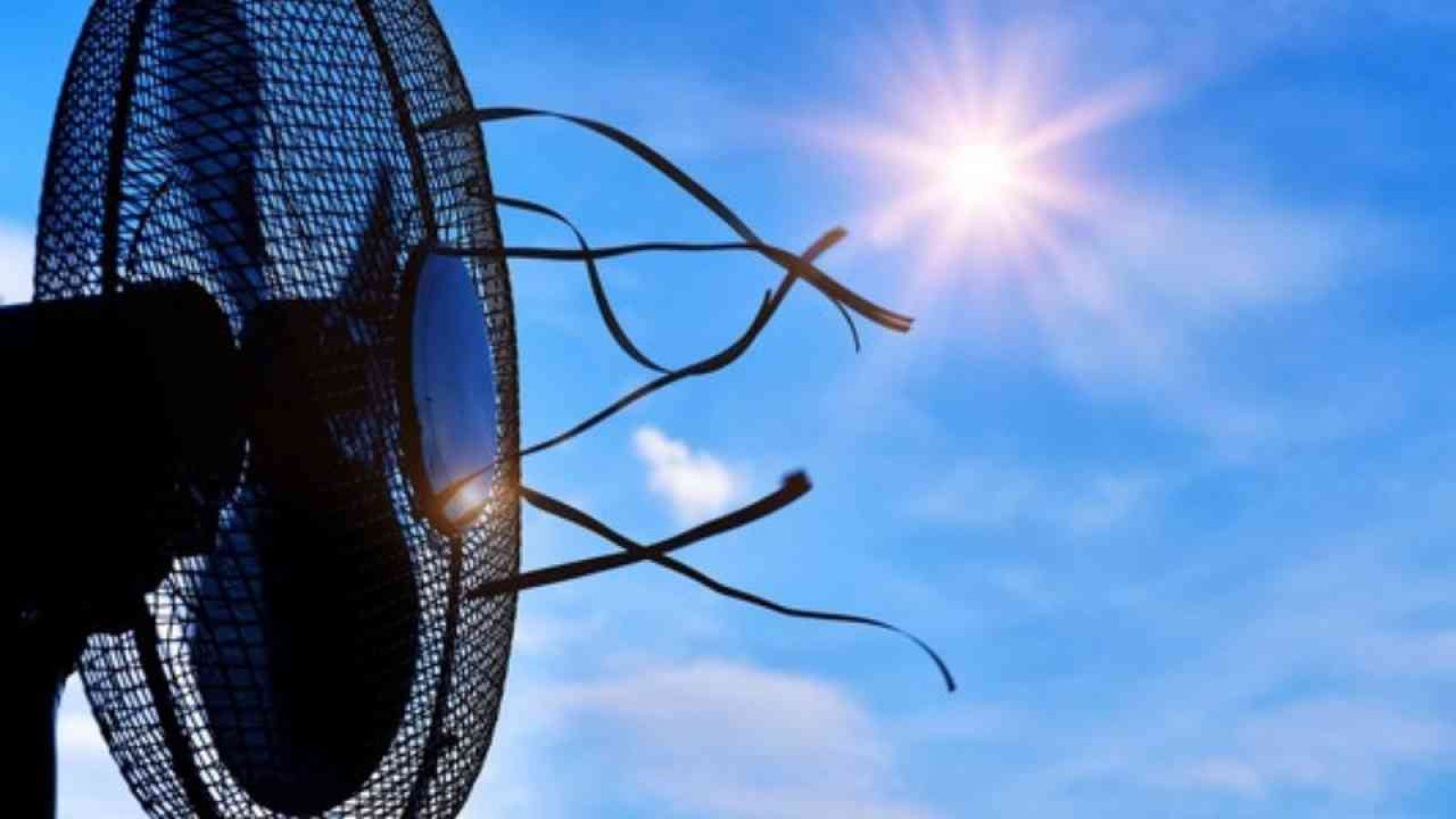 Ein Ventilator mit sichtbaren Kabeln vor einem blauen Himmel mit Sonnenstrahlen.