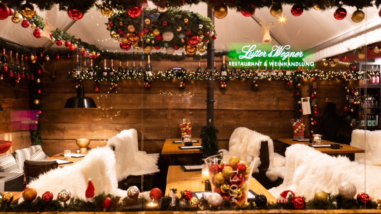 Gemütlicher Innenraum eines Restaurants mit festlicher Weihnachtsdekoration und Tischen.