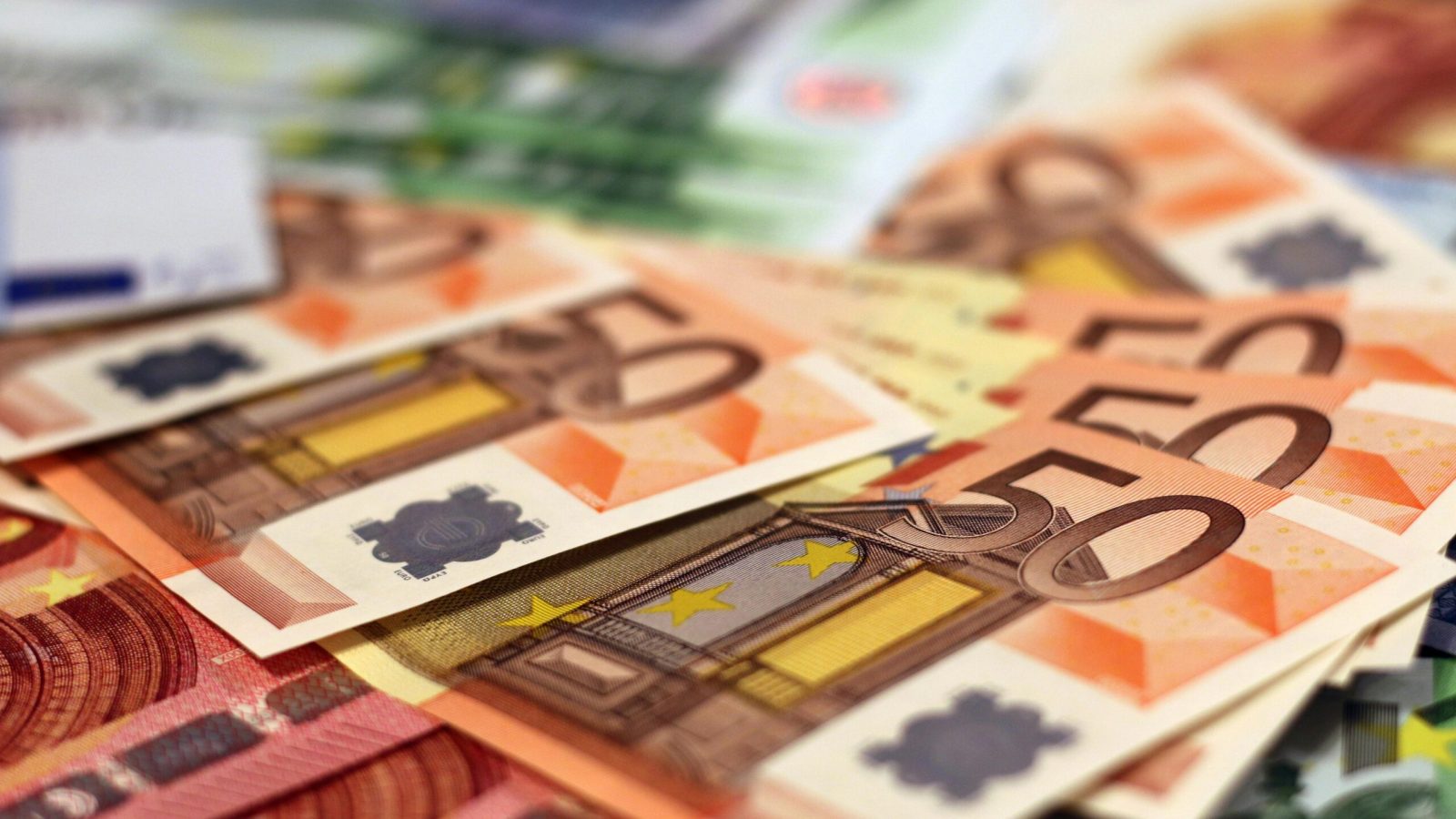 Fünfzig-Euro-Scheine liegen auf einem Haufen von verschiedenen Euro-Banknoten.