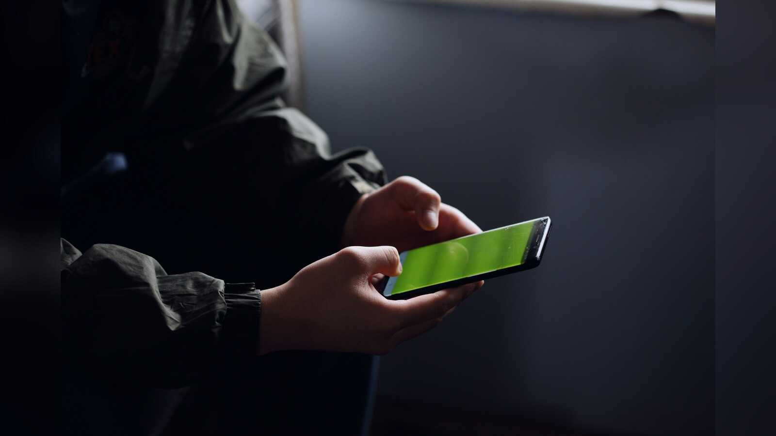 Hände halten ein Smartphone mit gesprungenem Display (Symbolbild Cybermobbing)