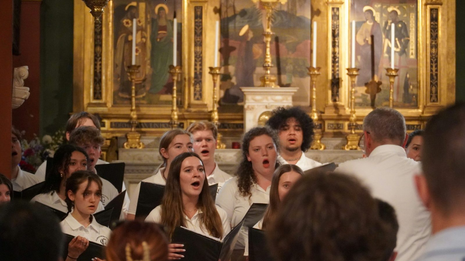 Chor beim gemeinsamen Singen, Dirigent im Vordergrund