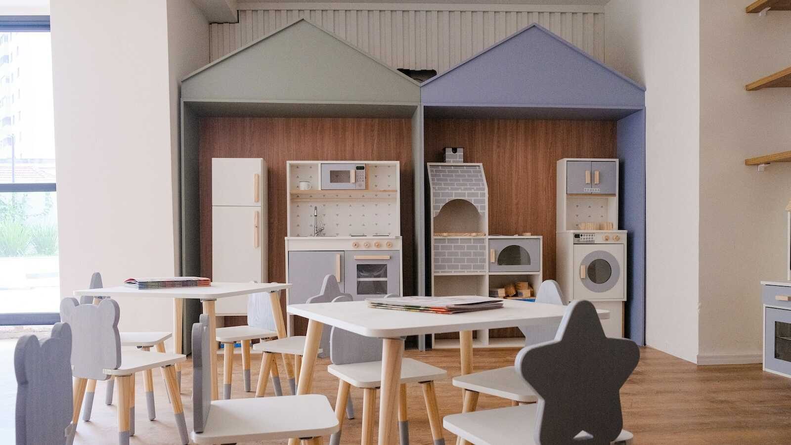 Spielküche mit kleinen Tischen und Stühlen in einem Gruppenraum einer Kindertageseinrichtung