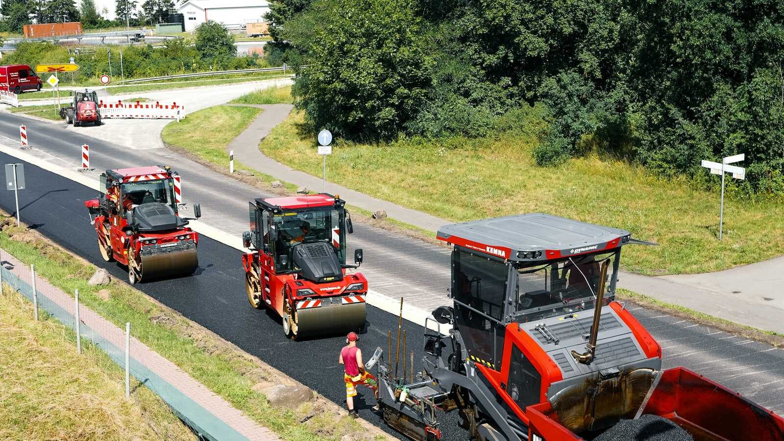 Straßenwalze verdichtet frischen Asphalt bei nächtlichen Bauarbeiten, Symbolbild