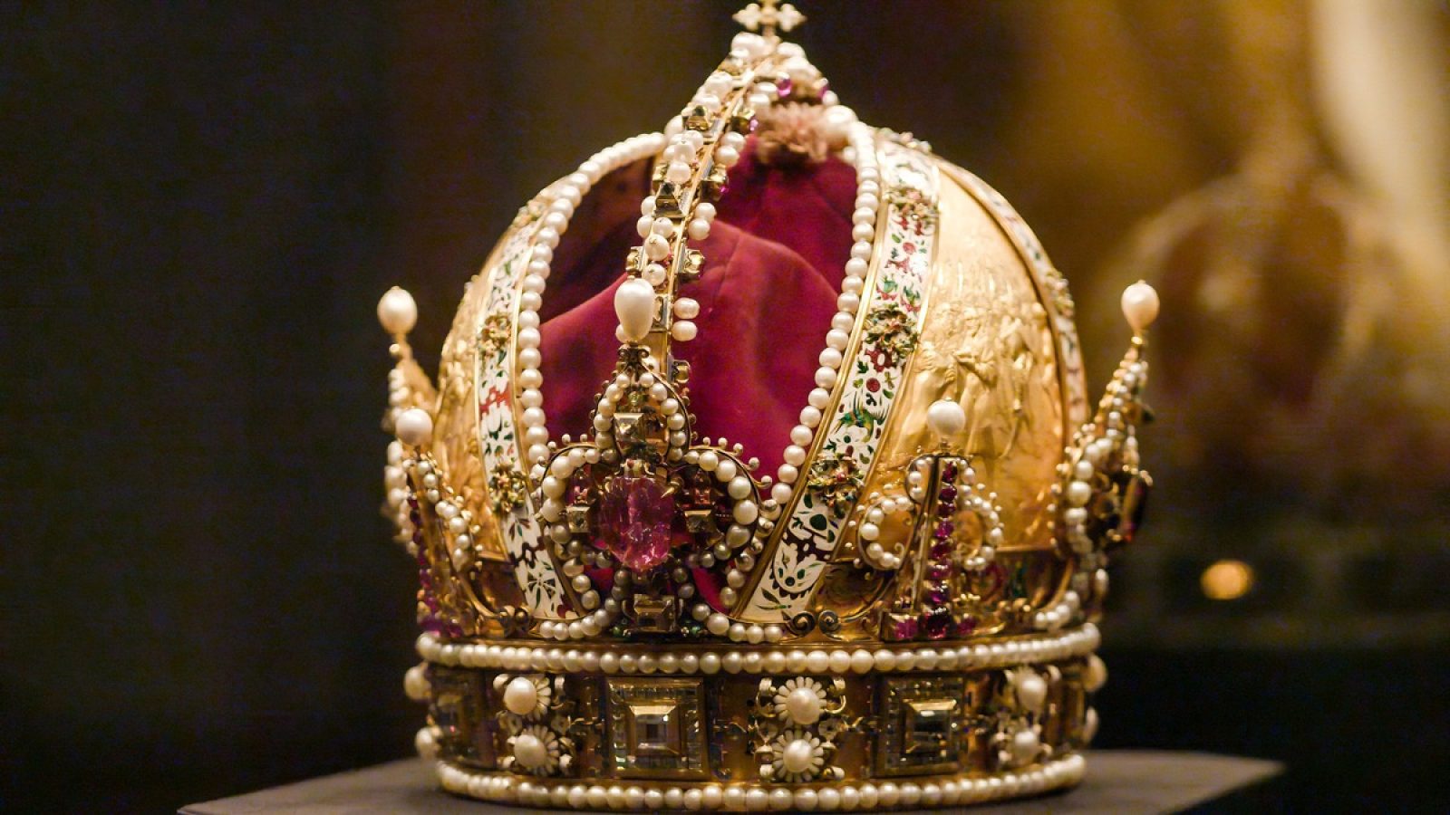 Königliche Krone mit Gold, Perlen und Edelsteinen, ausgestellt in einem Museum.